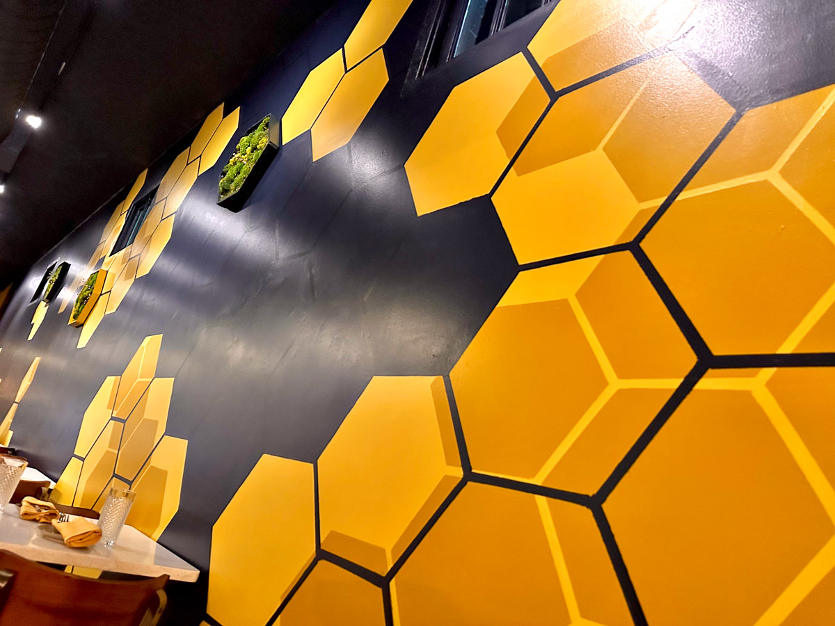 black wall with yellow hexagon mural